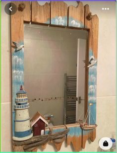 a bathroom mirror with a lighthouse painted on it