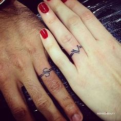 two people with matching wedding rings on their fingers, one has a cross and the other has a heart