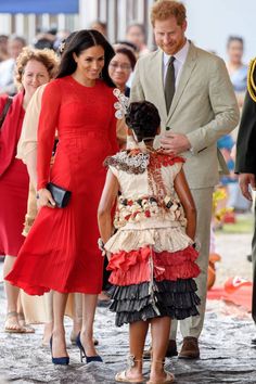 prince harry and his wife, princess charlotte, are greeted by people in red dresses