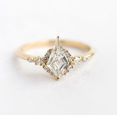 a gold ring with a white diamond in the center and two smaller diamonds on each side