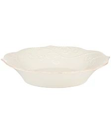 a white bowl with an ornate design on the bottom and side, sitting on a white surface