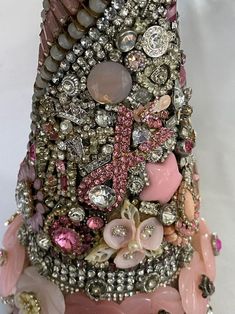 a pink vase with lots of different types of buttons and beads on it's side