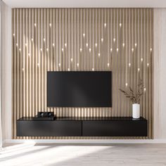 a modern living room with a flat screen tv mounted on the wall and wooden slats behind it