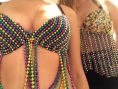 two women wearing beaded bras and one has her back turned to the camera