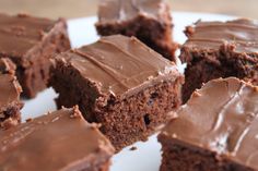 chocolate brownies with frosting on a white plate