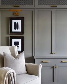 a living room filled with furniture and framed pictures