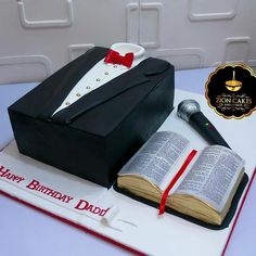 a birthday cake with an open book and microphone