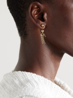 Gucci's gold-tone earrings feature a script version of the house's logo suspended from barbell-inspired posts. Wear yours as part of a stack with dainty studs. Classic Gucci Earrings For Anniversary, Gucci White Gold Sterling Silver Earrings, Gucci Luxury Sterling Silver Earrings, Gucci Sterling Silver Earrings As Gift, Gucci Sterling Silver Earrings For Gift, Elegant Gucci Sterling Silver Earrings, Luxury Gucci Sterling Silver Earrings, Luxury Gucci Yellow Gold Earrings, Gucci Luxury Drop Earrings