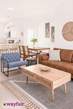 a living room filled with furniture next to a kitchen and dining room table on top of a rug