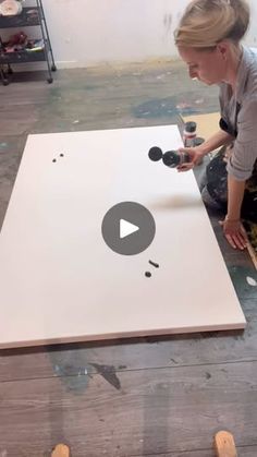 a woman is working on an art project with paint and wood planks in front of her