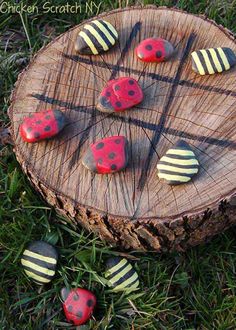 four red and white buttons sitting on top of a piece of wood in the grass