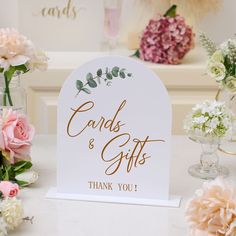 there are flowers and vases on the table with cards and gifts written on them