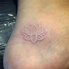 a small tattoo on the foot of a person with a flower in it's center