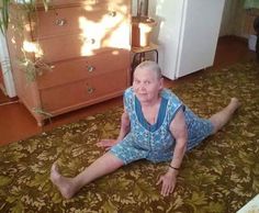 an older woman sitting on the floor in front of a dresser and chest freezer