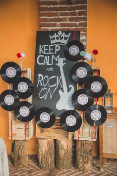 there is a sign that says keep calm and rock on in front of some old records