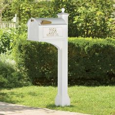 a white mailbox sitting on top of a lush green field