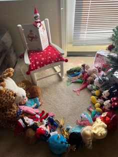 a group of stuffed animals sitting on top of a floor next to a christmas tree