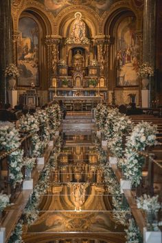 the interior of a church decorated with flowers and greenery