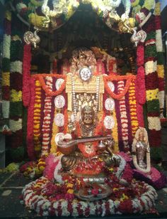 an idol in the middle of a stage decorated with flowers