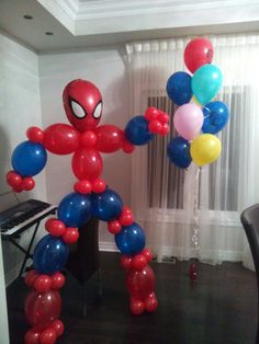 the balloon man is standing in front of a piano with balloons attached to it's legs