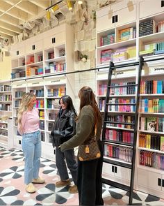 three women are looking at books in a book store