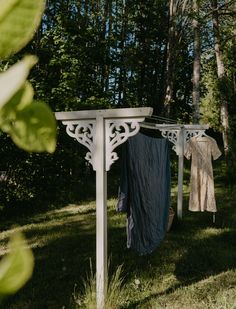 clothes hanging out to dry in the sun on a clothesline near some trees and grass