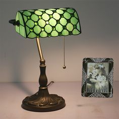 a lamp that is sitting on a table next to a picture and a framed photo