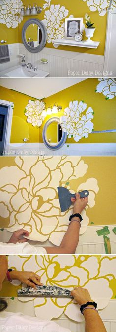 the process of painting a wall with yellow and white flowers