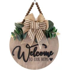 a welcome sign hanging from the side of a wooden plaque that says welcome to our home