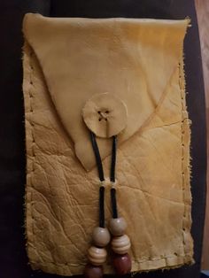 a piece of leather with beads hanging from it