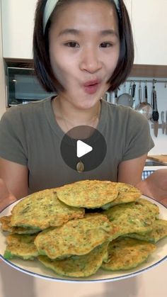 a woman making a funny face while holding a plate of food with pancakes on it