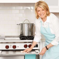 a woman is standing in front of an oven