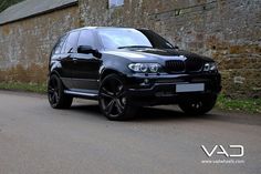 a black suv parked on the side of a road