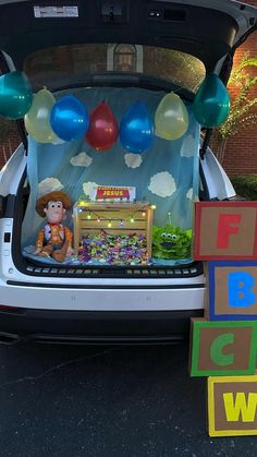 the trunk of a car is decorated with balloons and decorations