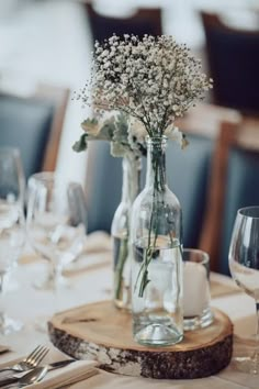 there is a vase with flowers in it on top of a wooden board at the table