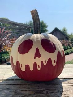 a painted pumpkin sitting on top of a wooden table