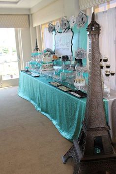 the eiffel tower is set up in front of a table with desserts on it