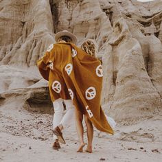 two people walking in the desert under a blanket