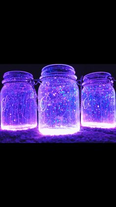 four mason jars filled with purple and blue lights