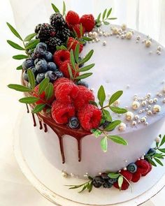 a white cake topped with berries and blueberries