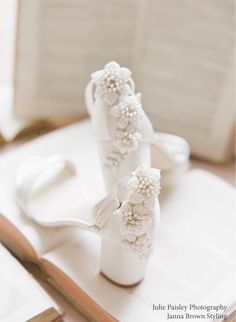 two white vases sitting on top of a table next to scissors and other items