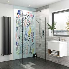 a bathroom with a shower, sink and mirror next to a wall mounted radiator