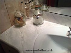 a bathroom sink with two jars sitting on top of it