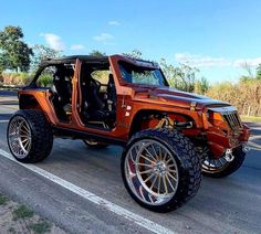 an orange jeep is parked on the side of the road