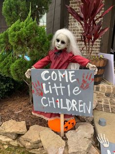 a creepy doll holding a sign that says come little children