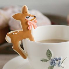 a cup of coffee with a cookie in the shape of a deer