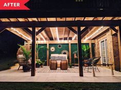 an outdoor living area is lit up at night with string lights on the roof and patio furniture