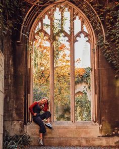 a person sitting on the steps in front of a window