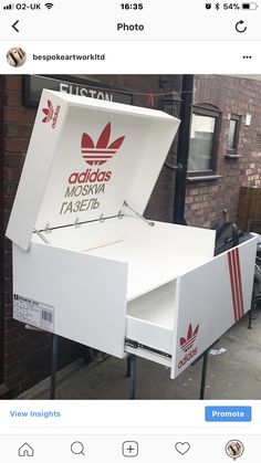 the adidas fast food delivery box has been placed in front of a brick building