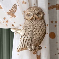 an owl figurine sitting on top of a curtain